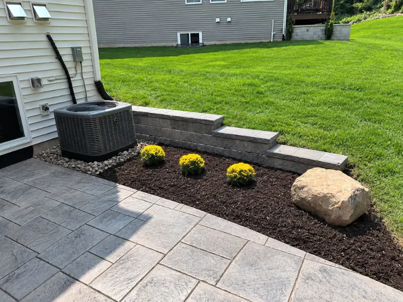 Landscape bed with mulch and retaining wall by Legacy Lawn And Landscape